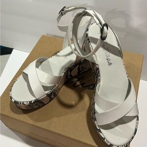 Matisse while platform sandals with snake skin around the bottom.